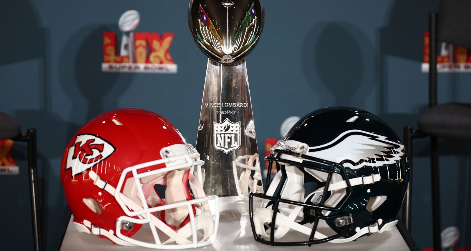 Chiefs and Eagles helmets with the Super Bowl Trophy ahead of their 2025 rematch.