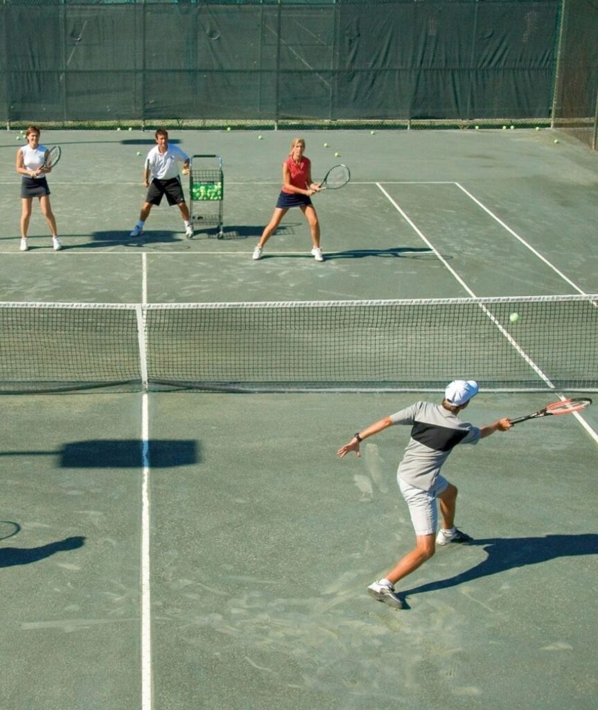 Best Hotels in Tampa Florida: Luxury Suites & Family-Friendly Stays at Saddlebrook Resort 22 Guests participating in a lively tennis session at Saddlebrook Resort, highlighting its comprehensive resort experience beyond basic hotels with world-class sports facilities and coaching.