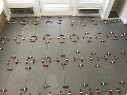 Tile Installation Barrie: Expert Craftsmanship for Beautiful and Lasting Surfaces 10 Newly tiled floor with many leveling clips and wedges ensuring perfectly even tiles.